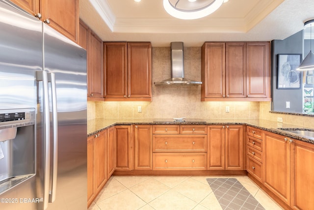 2515 S Atlantic Ave Unit 703, Daytona Beach, FL 32118 - kitchen featuring stainless steel refrigerator with ice dispenser, wall chimney exhaust hood, a tray ceiling, brown cabinets, and ornamental molding