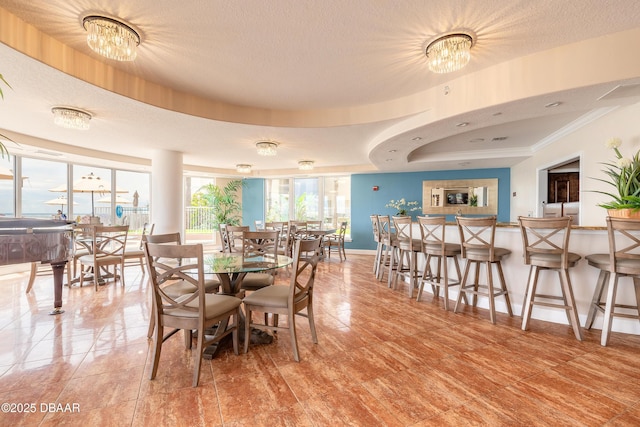 2515 S Atlantic Ave Unit 703, Daytona Beach, FL 32118 - dining room featuring a chandelier, a textured ceiling, crown molding, and a raised ceiling
