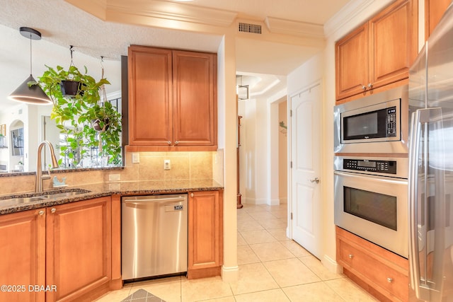 2515 S Atlantic Ave Unit 703, Daytona Beach, FL 32118 - kitchen featuring stainless steel appliances, light tile patterned flooring, crown molding, stone countertops, and tasteful backsplash