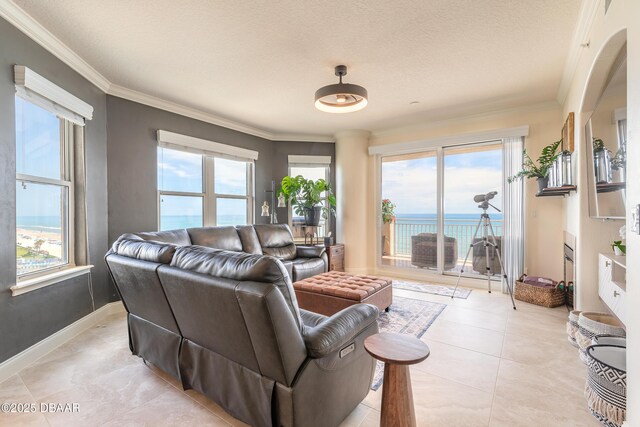 2515 S Atlantic Ave Unit 703, Daytona Beach, FL 32118 - living room with plenty of natural light, ornamental molding, a water view, and light tile patterned floors