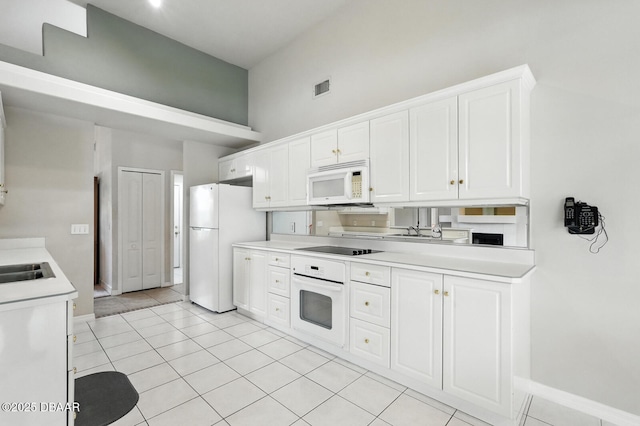 3776 Sweet Grove Ct, Port Orange, FL 32129 - kitchen featuring white appliances, light countertops, white cabinetry, and light tile patterned floors
