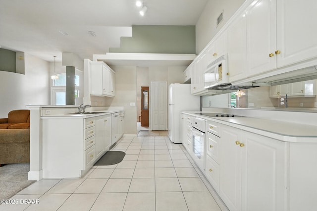 3776 Sweet Grove Ct, Port Orange, FL 32129 - kitchen featuring white appliances, white cabinets, light countertops, light tile patterned flooring, and a peninsula