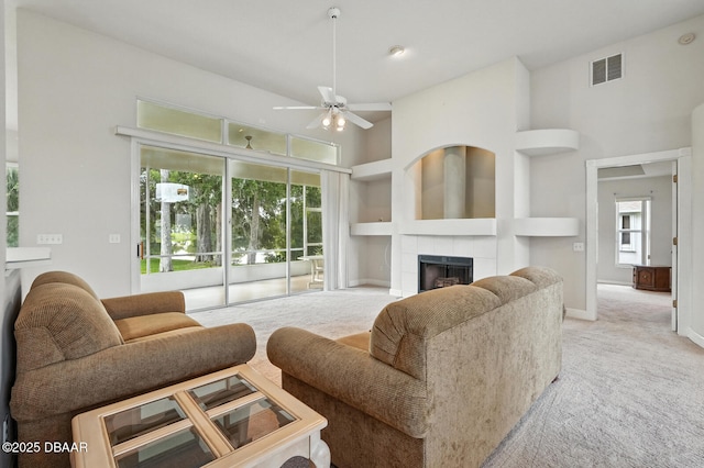 3776 Sweet Grove Ct, Port Orange, FL 32129 - carpeted living room featuring a tiled fireplace, ceiling fan, and a towering ceiling