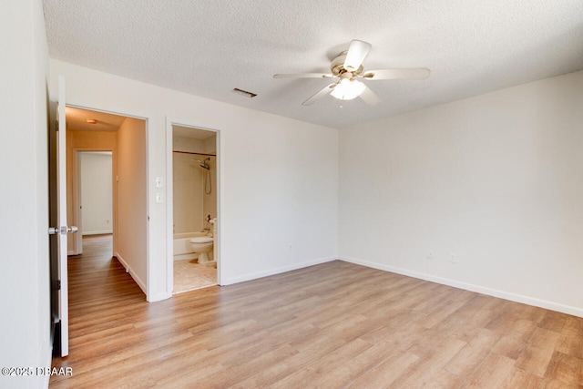 188 W Sandalwood Ct, Daytona Beach, FL 32119 - unfurnished bedroom featuring baseboards, light wood-type flooring, a textured ceiling, and connected bathroom