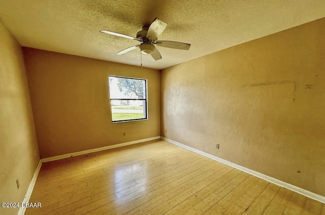 spare room with a textured ceiling, light hardwood / wood-style flooring, and ceiling fan