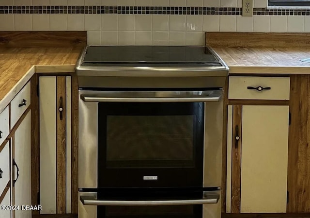 interior details with tasteful backsplash and stainless steel range with electric cooktop