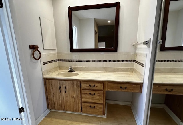 bathroom with vanity, hardwood / wood-style flooring, and backsplash