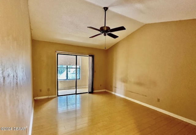 unfurnished room with a textured ceiling, hardwood / wood-style floors, lofted ceiling, and ceiling fan