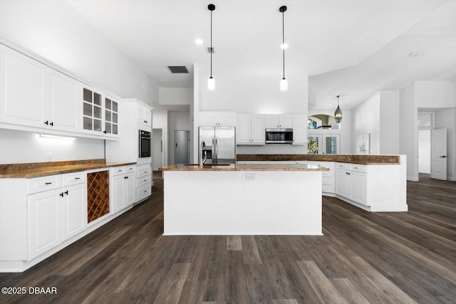 kitchen with pendant lighting, white cabinetry, dark hardwood / wood-style flooring, a kitchen island with sink, and stainless steel appliances