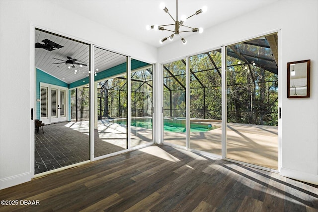 interior space featuring lofted ceiling, hardwood / wood-style floors, and ceiling fan with notable chandelier