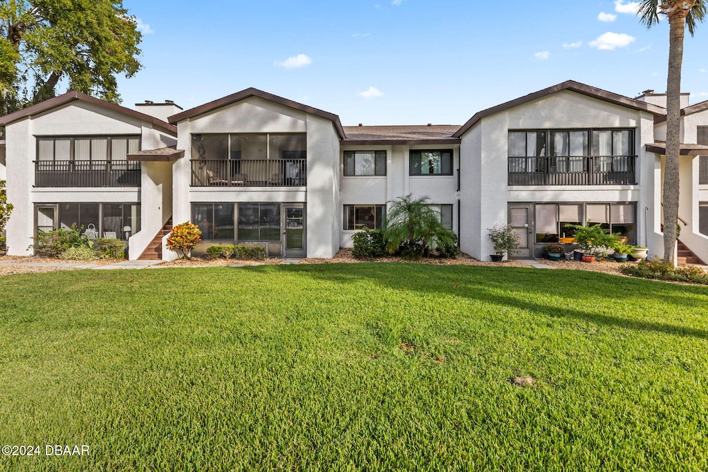 rear view of property with a lawn