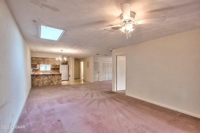 16 Red Maple Cir, Ormond Beach, FL 32174 - unfurnished living room featuring a skylight, ceiling fan with notable chandelier, visible vents, light carpet, and baseboards