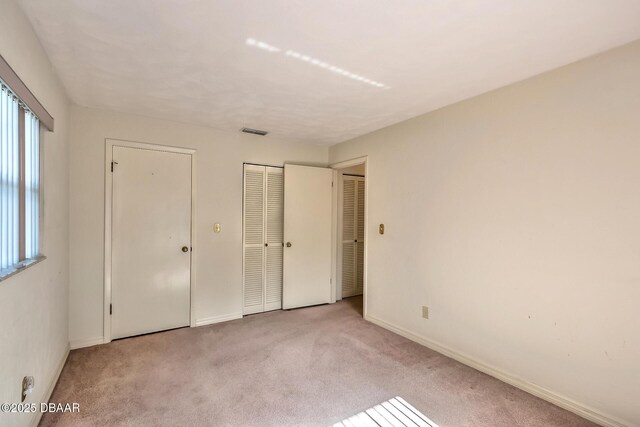 16 Red Maple Cir, Ormond Beach, FL 32174 - unfurnished bedroom featuring carpet, visible vents, and multiple windows