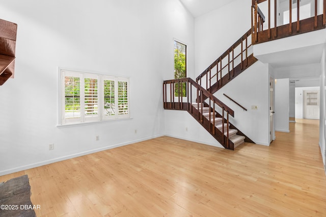 living room featuring a towering ceiling and light hardwood / wood-style flooring