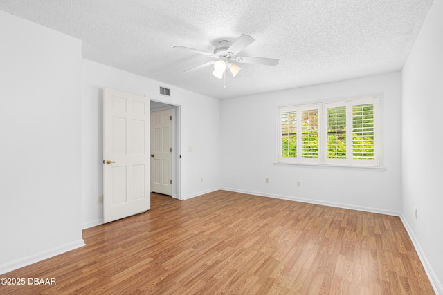 unfurnished room with ceiling fan, a textured ceiling, and light wood-type flooring