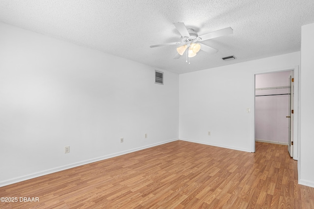 unfurnished room with a textured ceiling, ceiling fan, and light hardwood / wood-style flooring