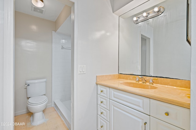 bathroom with tile patterned floors, toilet, vanity, and a tile shower