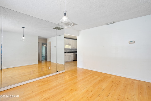 interior space with sink, a textured ceiling, and light hardwood / wood-style flooring