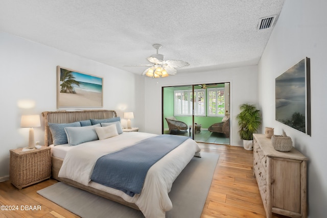 bedroom featuring ceiling fan, access to exterior, a textured ceiling, and light hardwood / wood-style flooring