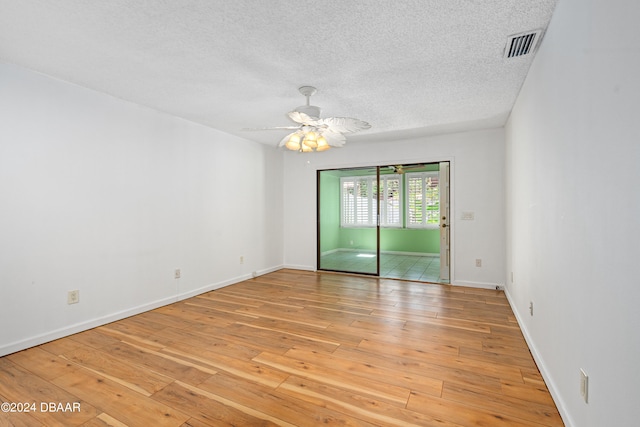 spare room featuring a textured ceiling, ceiling fan, and light hardwood / wood-style flooring