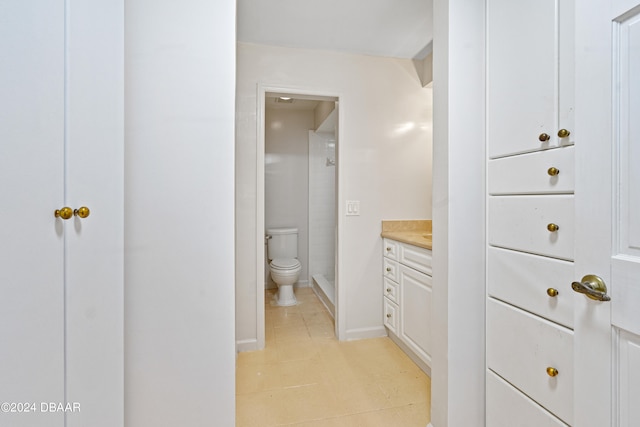 bathroom with toilet, vanity, and a shower