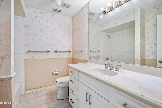 full bathroom with toilet, tiled shower / bath combo, tile patterned floors, a textured ceiling, and vanity