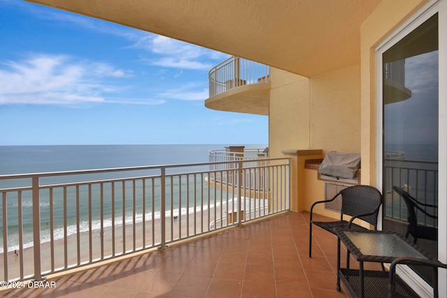 balcony featuring a water view and a view of the beach