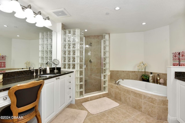 bathroom featuring independent shower and bath, vanity, and tile patterned floors