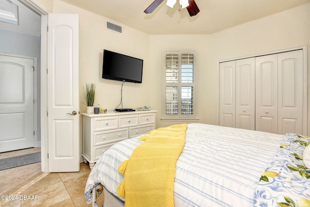 bedroom with a closet, light tile patterned floors, and ceiling fan