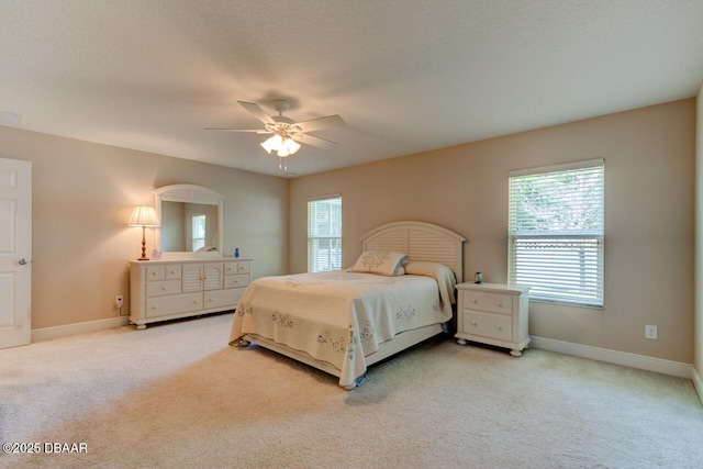 carpeted bedroom with a textured ceiling, ceiling fan, and baseboards