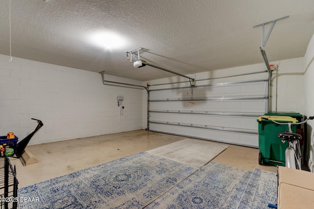 garage with concrete block wall and a garage door opener