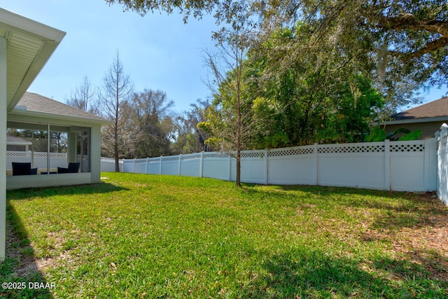 view of yard with a sunroom and a fenced backyard