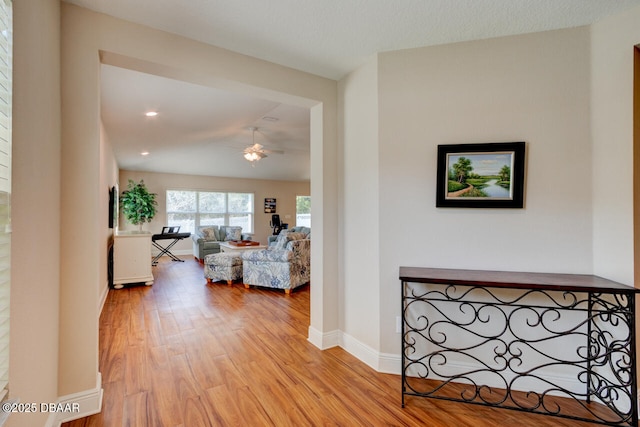 corridor featuring light wood-type flooring and baseboards