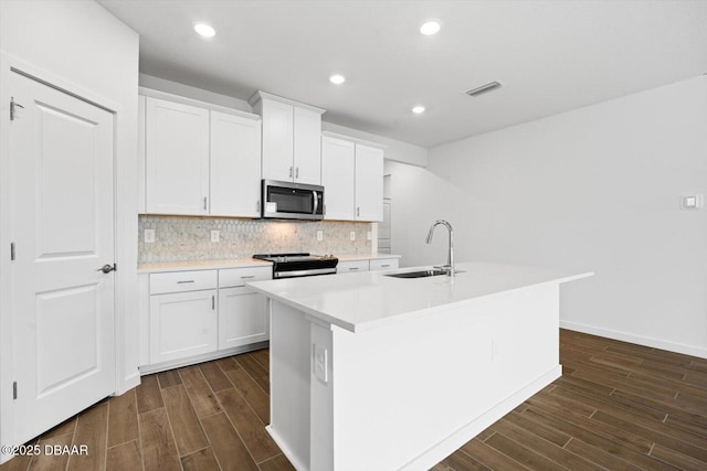 kitchen with sink, white cabinetry, stainless steel appliances, and a kitchen island with sink