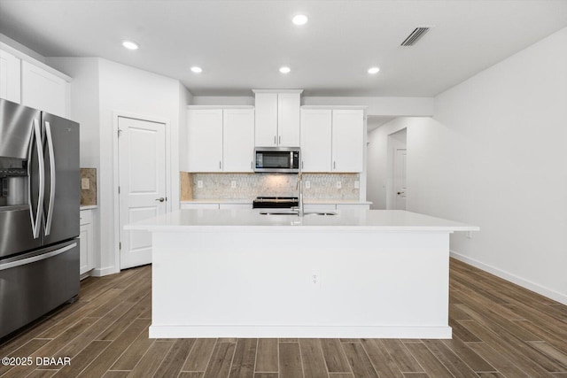 kitchen with white cabinets, a center island with sink, and stainless steel appliances