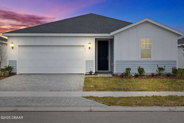 ranch-style house with a garage and a yard