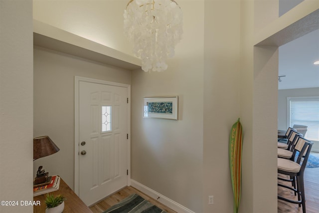 entryway featuring an inviting chandelier, a wealth of natural light, and wood-type flooring