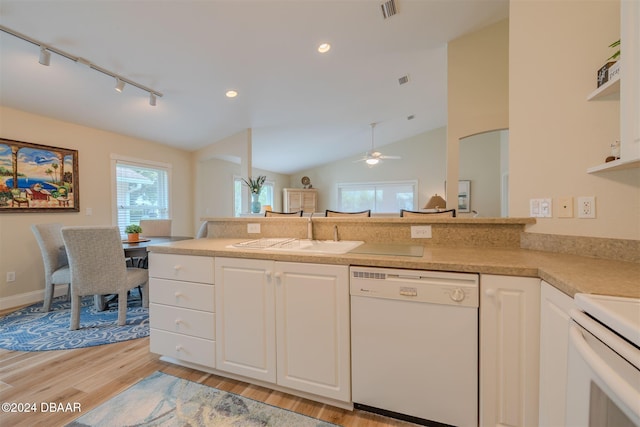 kitchen with light wood-type flooring, sink, vaulted ceiling, white cabinets, and white appliances