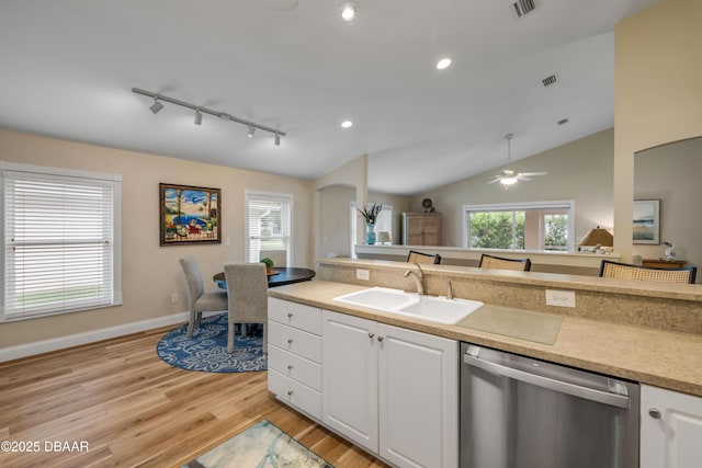 682 Middlebury Loop, New Smyrna Beach, FL 32168 - kitchen with dishwasher, rail lighting, arched walkways, light wood-style flooring, and white cabinets
