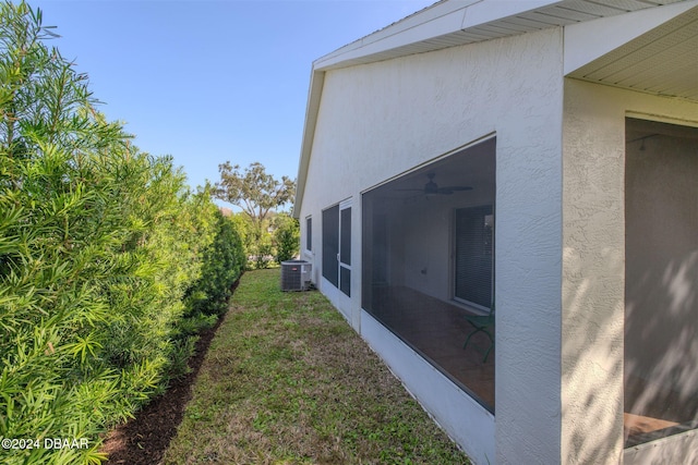 682 Middlebury Loop, New Smyrna Beach, FL 32168 - view of side of property with stucco siding, ceiling fan, a lawn, and a sunroom