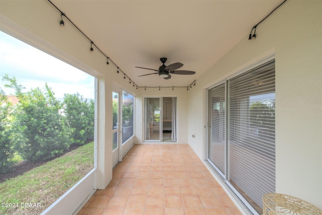 unfurnished sunroom with a healthy amount of sunlight and ceiling fan