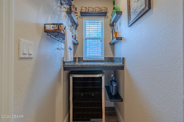 682 Middlebury Loop, New Smyrna Beach, FL 32168 - stairs with wine cooler, a textured wall, baseboards, and a dry bar