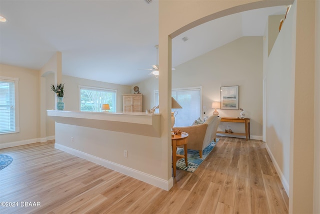 corridor featuring vaulted ceiling and light hardwood / wood-style flooring