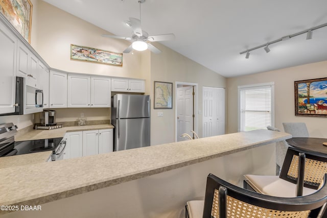 682 Middlebury Loop, New Smyrna Beach, FL 32168 - kitchen featuring appliances with stainless steel finishes, light countertops, rail lighting, lofted ceiling, and a ceiling fan