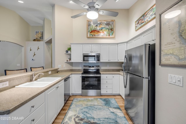 682 Middlebury Loop, New Smyrna Beach, FL 32168 - kitchen featuring appliances with stainless steel finishes, light wood-style flooring, a peninsula, white cabinets, and ceiling fan