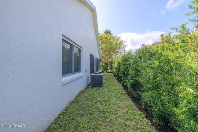 682 Middlebury Loop, New Smyrna Beach, FL 32168 - view of side of property with central AC, stucco siding, and a lawn