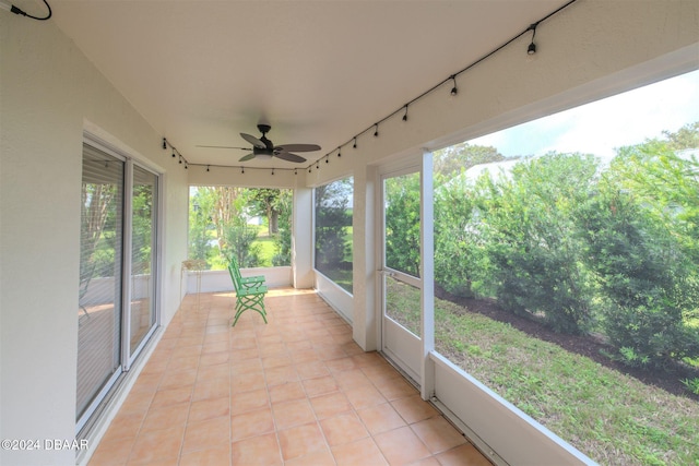 unfurnished sunroom with ceiling fan and plenty of natural light