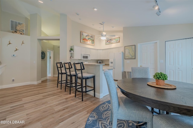 682 Middlebury Loop, New Smyrna Beach, FL 32168 - dining room featuring light wood-type flooring, high vaulted ceiling, baseboards, a ceiling fan, and rail lighting