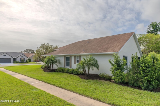 682 Middlebury Loop, New Smyrna Beach, FL 32168 - view of front of house featuring stucco siding, a front yard, and roof with shingles
