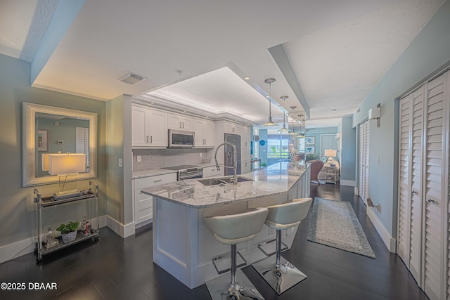 4565 S Atlantic Ave Unit 5501, Port Orange, FL 32127 - kitchen with stainless steel appliances, a sink, white cabinetry, dark wood-style floors, and baseboards